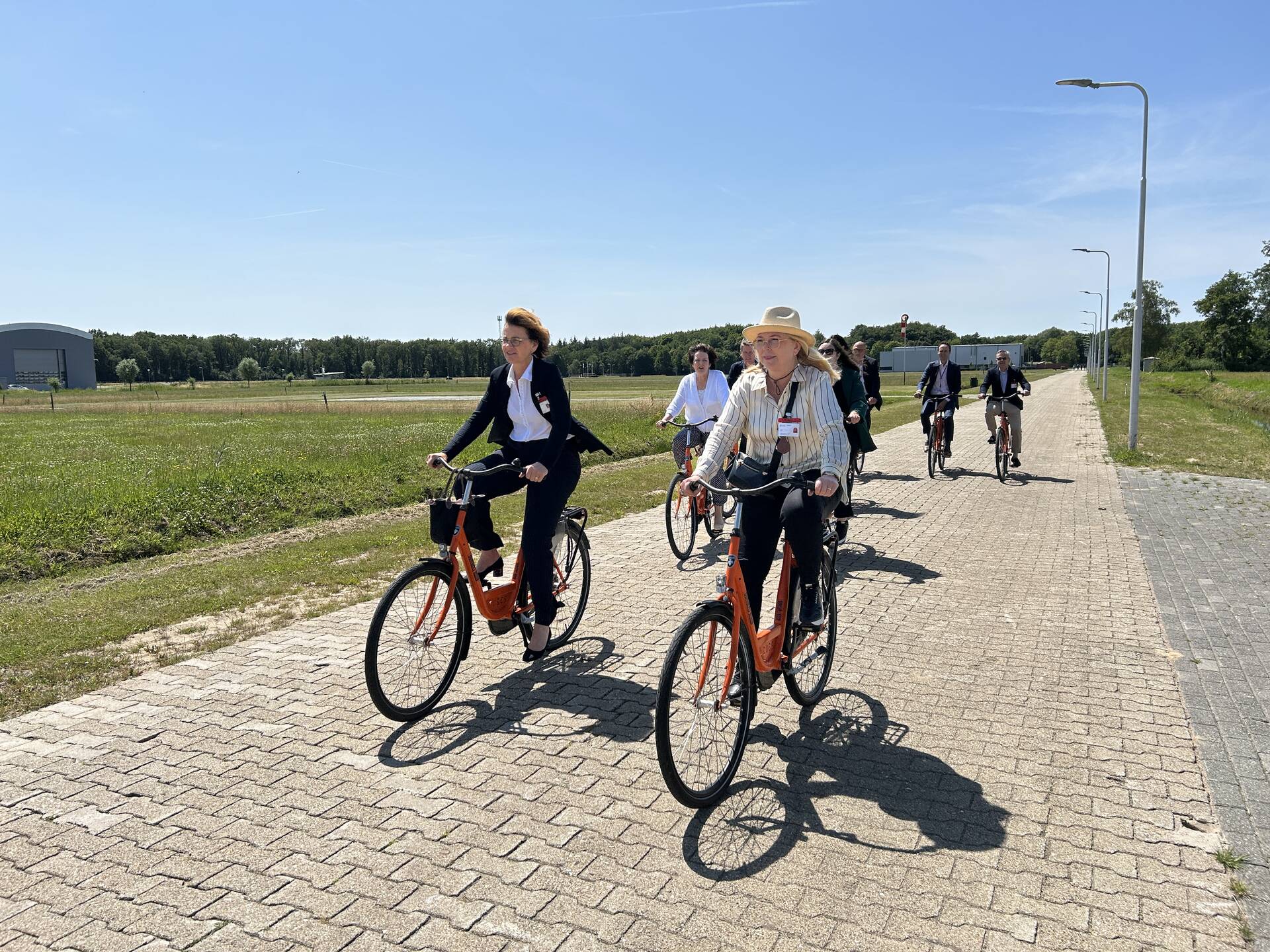 De delegatieleden gingen per fiets over het terrein van het Nederlands Lucht- en Ruimtevaartcen-trum naar de German-Dutch Wind Tunnels