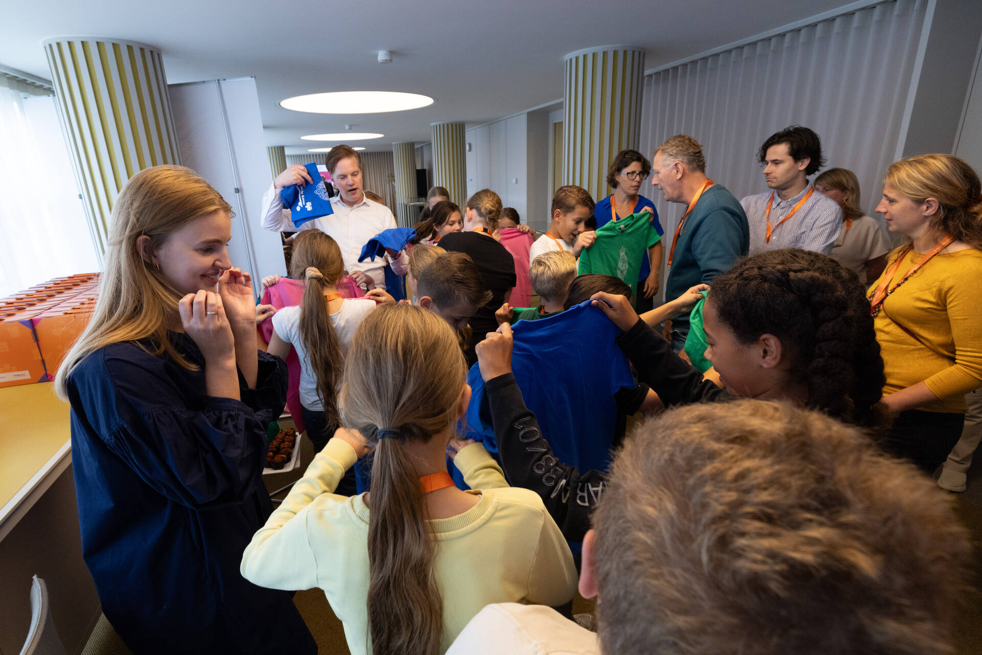 De leerlingen wachten tot ze de plenaire zaal in mogen